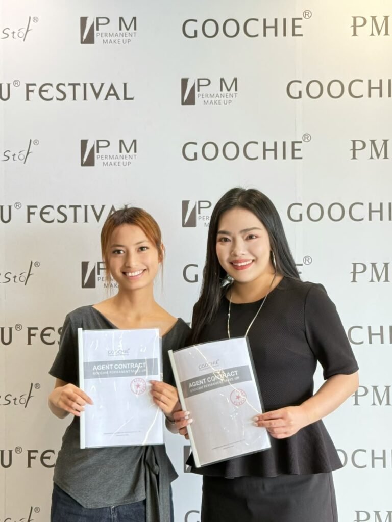 Artistry Academy team members holding Goochie Permanent Makeup agent contracts at the PMU Festival